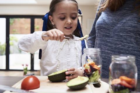 Portrait of little girl preparing healthy salad with her mother in the kitchen model released Symbolfoto property released  IGGF00003