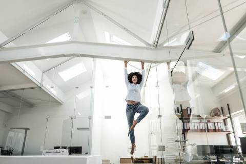 Young woman hanging on beam in office model released Symbolfoto property released  KNSF02350