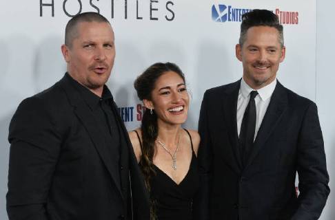 Cast members Christian Bale and Q orianka Kilcher join director Scott Cooper (R) on the red carpet during the premiere of the motion picture western Hostiles at the Academy of Motion Picture Arts & Sciences in Beverly Hills, California on December 14, 2017. Storyline: In 1892, a legendary Army captain reluctantly agrees to escort a Cheyenne chief and his family through dangerous territory.  LAP2017121405 JIMxRUYMEN