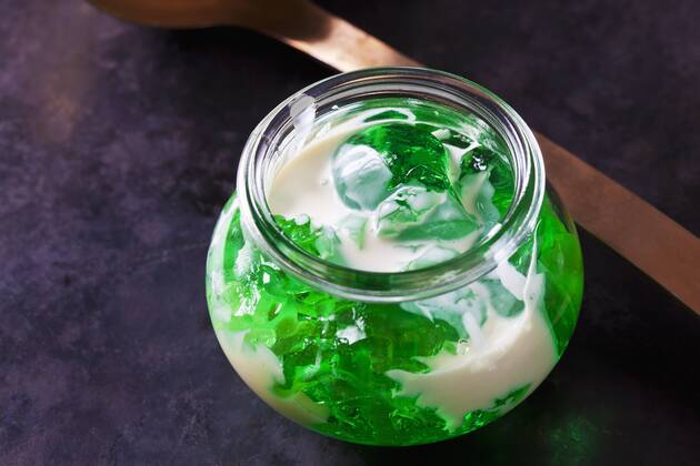 Green woodruff jelly in a glass with vanilla sauce  CSF28395