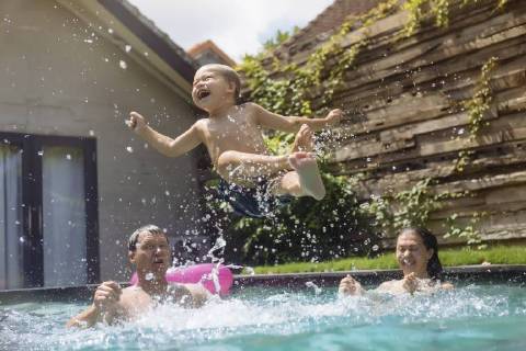 Happy family having fun in swimming pool model released Symbolfoto property released  KNTF00931