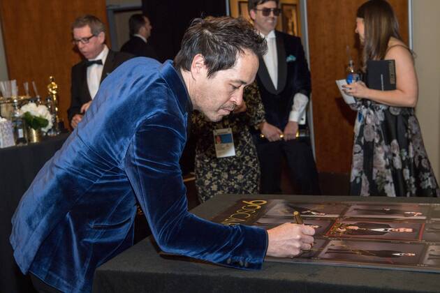 The Oscar winner for achievement in production design for work on The Shape of Water, Paul Denham Austerberry, signs a poster backstage during the live ABC Telecast of The 90th OscarsÂ® at the DolbyÂ® Theatre in Hollywood, CA on Sunday, March 4, 2018.  Copyright: xRobertxGladdenx 33546_542PLX
