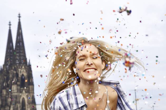 Germany, Cologne, portrait of happy blond woman in between shower of confetti model released Symbolfoto  FMKF04742