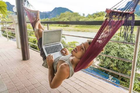 Laos, Vang Vieng, young man lying in hammock using laptop model released Symbolfoto  AFVF00297