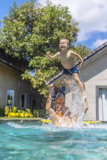 Father and son having fun in swimming pool model released Symbolfoto property released  KNTF01095