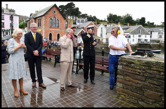 . 16 07 2018. Fowey, United Kingdom. Prince Charles the Duchess of Cornwall visit Cornwall. The Duke and Duchess of Cornwall put their fingers in their ears as the cannon gun is fired to launch the gig race as they visit the celebration of Fowey festival meeting local businesses, representatives from Fowey gig club and members of the RNLI on Fowey Quay.  xAndrewxParsonsx xi-Imagesx IIM-18220-0020