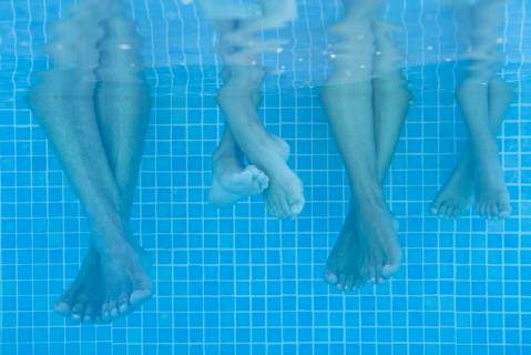 Family soaking feet in pool, underwater view  Copyright: AntoinexArraou B99695414