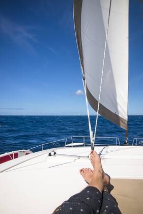 Low section view with feet of woman sunbathing on sailboat sailing in sea, Bourg de Saintes Iles de Saintes Guadeloupe BRCA003062 model released Symbolfoto Copyright: CatexBrown BRCA003062