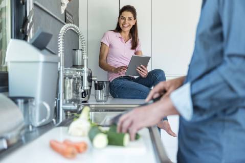 Happy couple in kitchen at home cooking and using a tablet model released Symbolfoto property released  DIGF04442