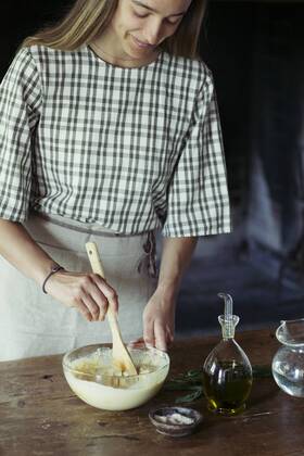 Young woman in kitchen preparing dough for fresh chickpea cake model released Symbolfoto  ALBF00448