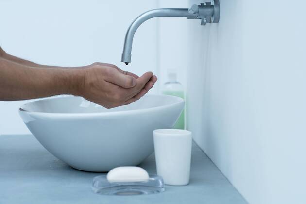 Man holding hands under dripping faucet in bathroom sink, cropped  Copyright: SannaxLindberg 35778585st