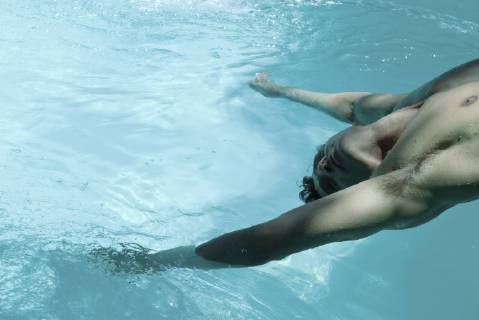 Man leaning backward over swimming pool, dangling arms in water  Copyright: MichèlexConstantini 35778335st