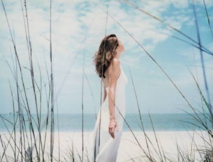 Woman standing at the beach with arms back, side view  Copyright: MatthieuxSpohn B06670204
