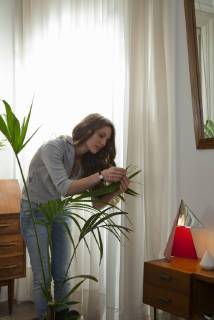 Woman caring for house plant  Copyright: SigridxOlsson B09117517
