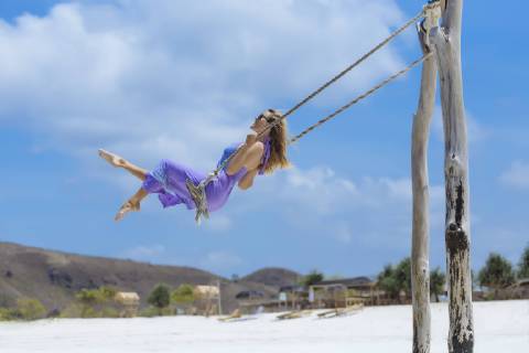 Side view of woman in purple dress on swing on beach, Kuta, Lombok, Indonesia, Kuta Lombok Indonesia TRKO020278 model released Symbolfoto Copyright: KonstantinxTrubavin TRKO020278