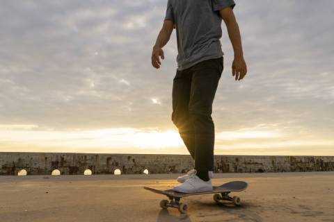 Young Chinese man skateboarding at sunsrise near the beach model released Symbolfoto  AFVF00735