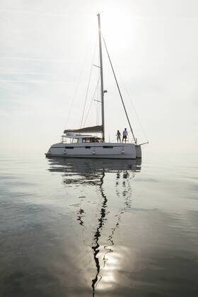Couple setting off for a sailing trip on a catamaran model released Symbolfoto property released  EBSF02664