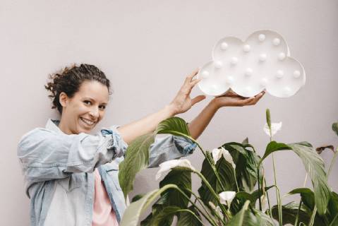Smiling woman holding cloud over house plant model released Symbolfoto property released  KNSF04083