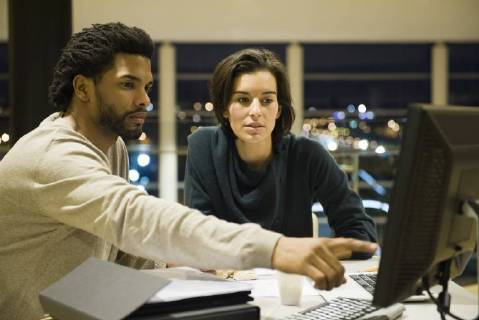 Colleagues working on project together in office at night Copyright: EricxAudras B29800417