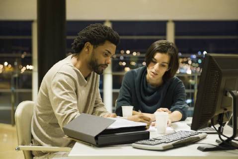 Colleagues working on project together in office at night Copyright: EricxAudras B75508917