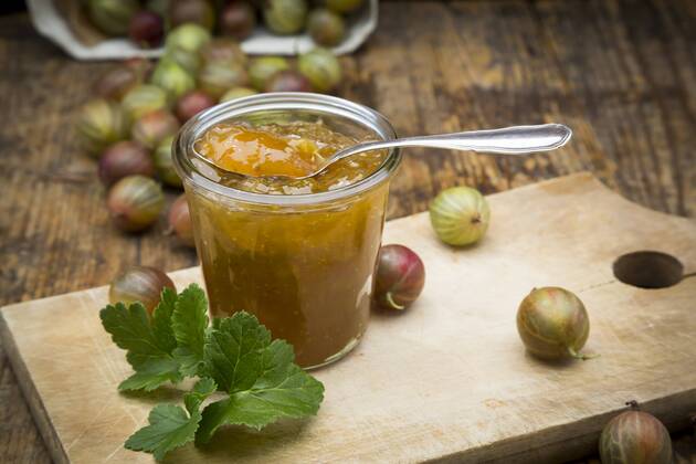 Jar of gooseberry jam and gooseberries on wooden board  LVF06268