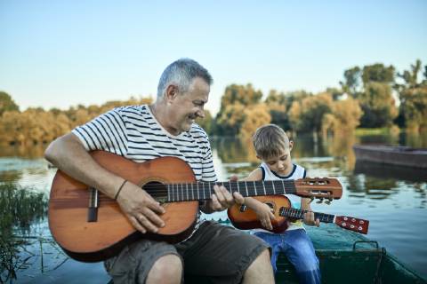 Grandfather teaching grandson playing guitar model released Symbolfoto ZEDF01497
