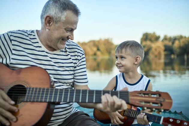 Grandfather teaching grandson playing guitar model released Symbolfoto ZEDF01498