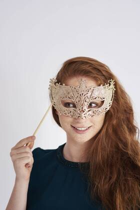 Portrait of smiling redheaded woman with masquerade mask model released Symbolfoto  ABIF00884