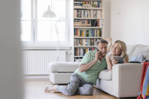 Mature couple at home using cell phone and tablet model released Symbolfoto property released  JOSF02446