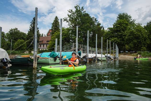 Lilli with her kayak on the Rhine in the port of Gaienhofen Lake Constance Baden Württemberg Germany Kayaking on the Upper Rhine on Lake Constance