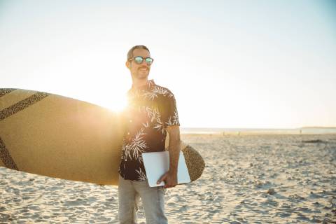 Man at the beach carrying surfboard and laptop model released Symbolfoto  SUF00564