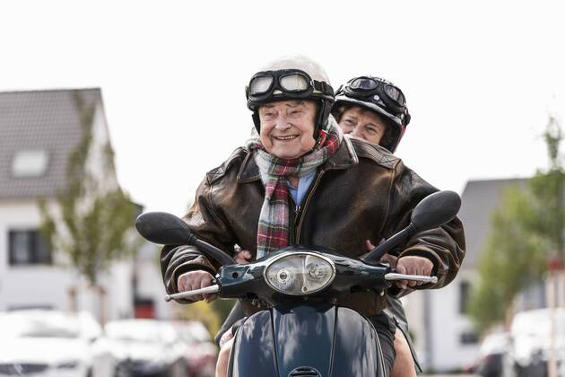 Happy senior couple riding motor scooter model released Symbolfoto  UUF14922