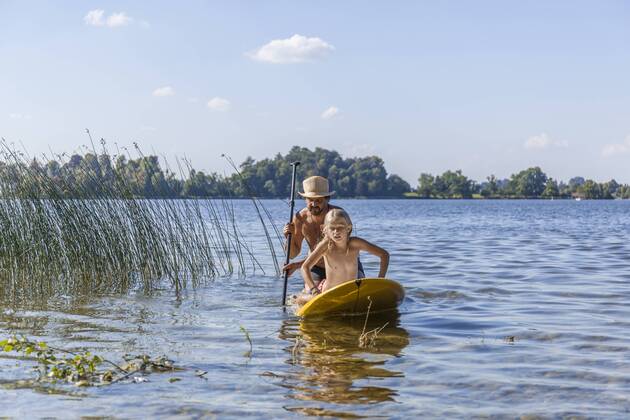 Father and daughter paddle boarding on lake model released Symbolfoto  TCF05674
