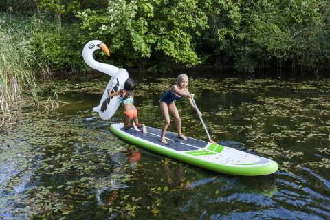 Two girls in a pond with inflatable pool toy in swan shape and SUP board model released Symbolfoto property released  TCF05737
