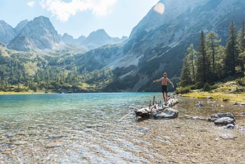 Austria, Tyrol, Young man at Lake Seebensee balancing on tree trunk model released Symbolfoto  DIGF04748
