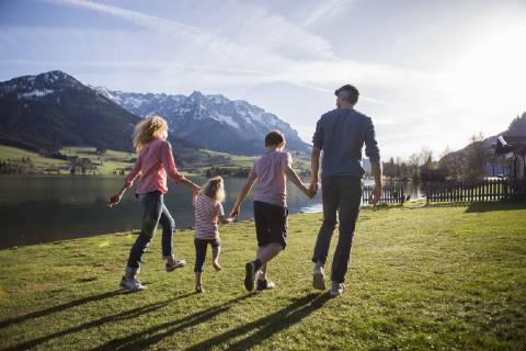 Austria, Tyrol, Walchsee, happy family walking at the lakeside model released Symbolfoto  JLOF00201