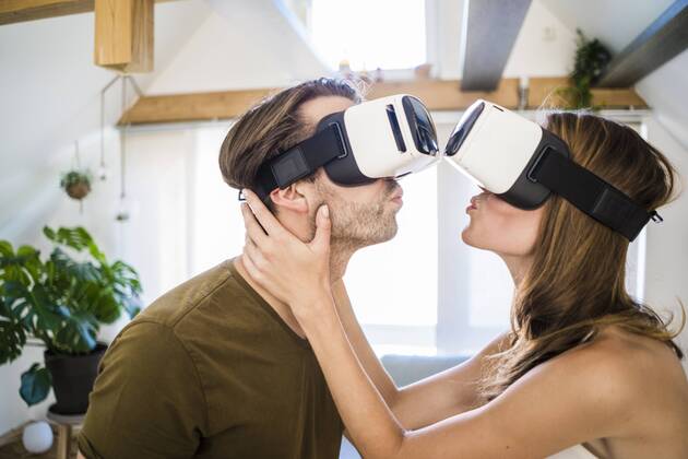 Couple wearing VR glasses kissing at home model released Symbolfoto property released  JOSF02635