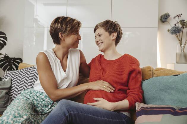 Happy lesbian couple touching belly of the expectant mother model released Symbolfoto property released  MFF04440