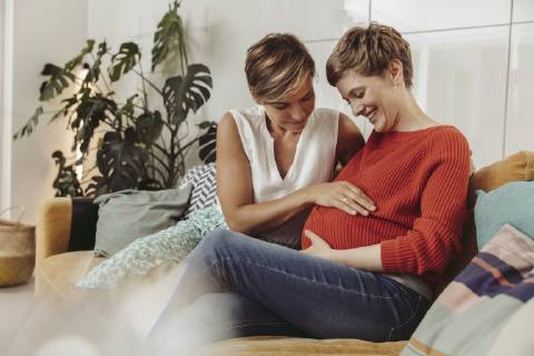 Happy lesbian couple touching belly of the expectant mother model released Symbolfoto property released MFF04442