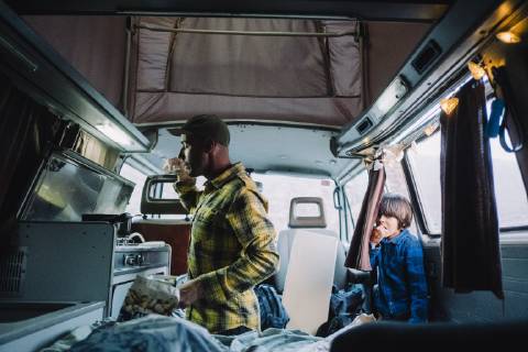 IMAGO Creative: Klimawandel - Nachhaltiges Reisen Man cooks in camper van as his son looks from the door, Tenerife, Canary Islands, Spain, Tenerife Canary Islands Spain VISE003976 model released Symbolfoto Copyright: SergioxVillalba VISE003976