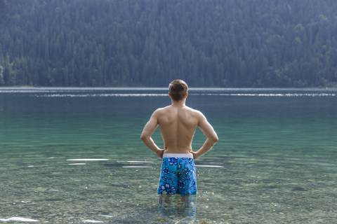 Germany, Bavaria, Eibsee, back view of young man standing in water model released Symbolfoto  TCF05446