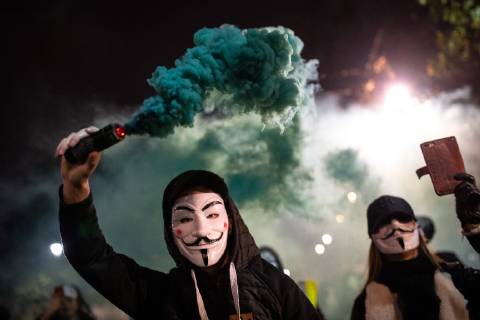November 5, 2018 - London, London, UK - London, UK. A demonstrator lights a flare as he takes part in the Million Mask March, an anti-capitalist protest organised by Anonymous UK. The march takes place on bonfire night, the anniversary of Guy Fawkes plot to blow up the Houses of Parliament with gunpowder. London UK  - ZUMAl94_ 20181105_zaf_l94_072 Copyright: xTomxNicholsonx