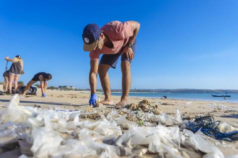 IMAGO Creative: Nächste Generation, Sozial- und klimabewusst Man bending while picking up trash at beach, Jimbaran, Bali, Indonesia, Jimbaran Bali Indonesia Copyright: KonstantinxTrubavin TRKO019933