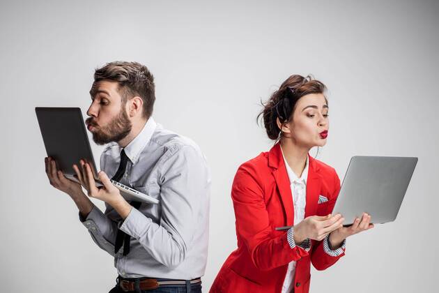  The young businessman and businesswoman with laptops kissing screens on gray background model released Symbolfoto  Copyright: xmaster1305x Panthermedia17714266