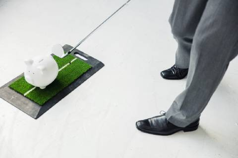Close-up of businessman playing golf with piggy bank model released Symbolfoto property released  MOEF01464
