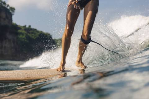 Low section shot of woman surfing, Kuta, Lombok, Indonesia, Kuta Lombok Indonesia model released Symbolfoto Copyright: KonstantinxTrubavin TRKO023353