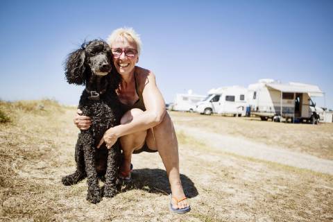 Woman embraces her dog king poodle at a campsite Portbail Normandie France Europe Copyright: imageBROKER/JanxTepass ibxjte04830927.jpg