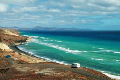 Fuerteventura view of the beach of Mal Nombre the turquoise blue sea and a camper Spain