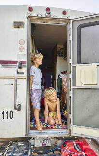 Two smiling boys looking out of door of a camper model released Symbolfoto property released  SSCF00080