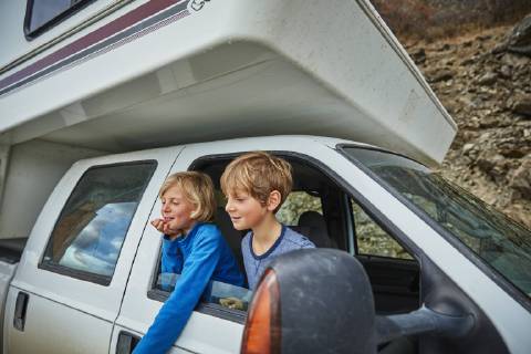 Two smiling boys looking out of window of a camper model released Symbolfoto property released  SSCF00241